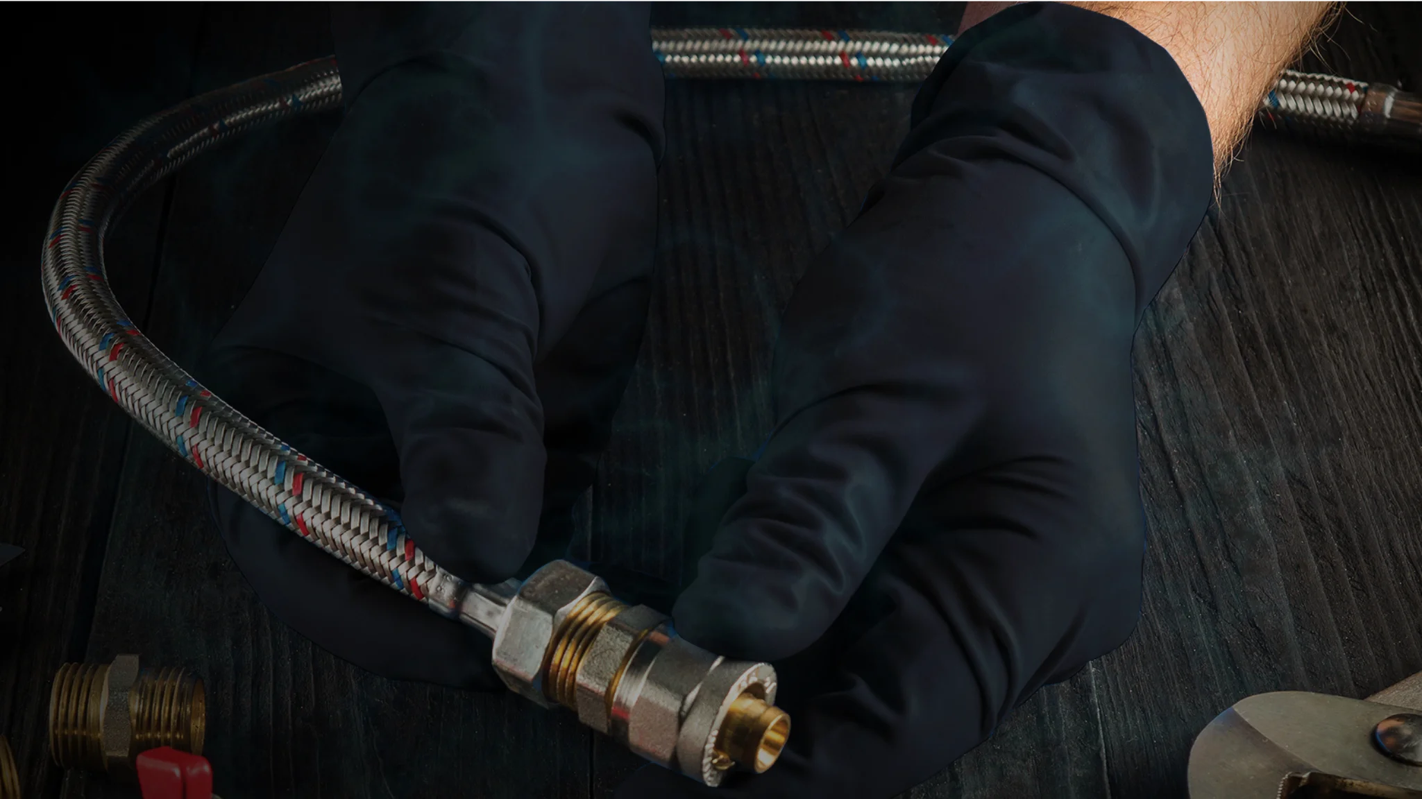 hands wearing black nitrile gloves holding plumbing parts