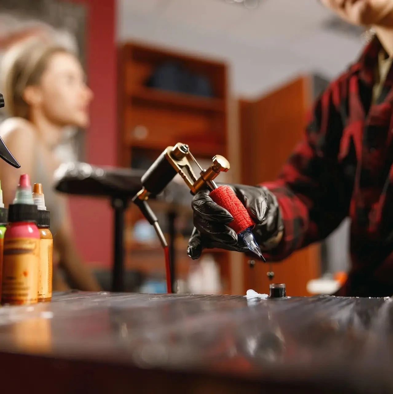 tattoo artist wearing small black nitrile gloves