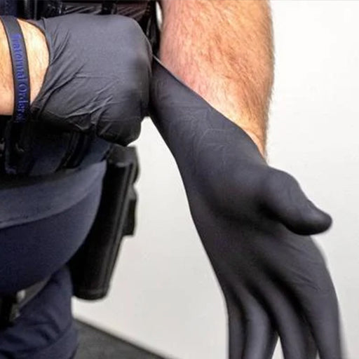 Law enforcement officer putting on black nitrile gloves